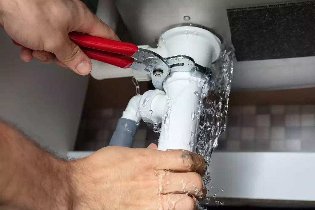 Emergency plumber repairing a burst pipe